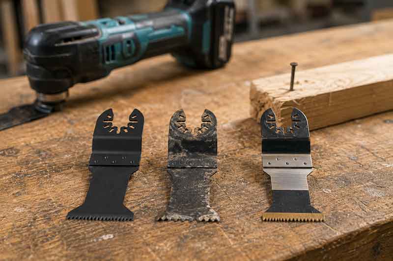Drei Multitool-Saegeblaetter auf Werkbank